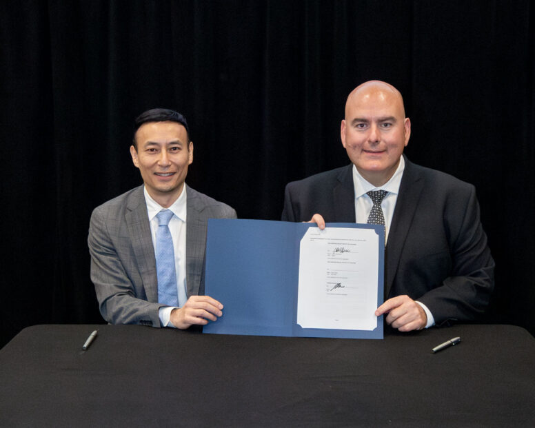 Mayor Steven Del Duca holding up a signed MOU with Executive Vice President of Development at QuadReal, Toby Wu.